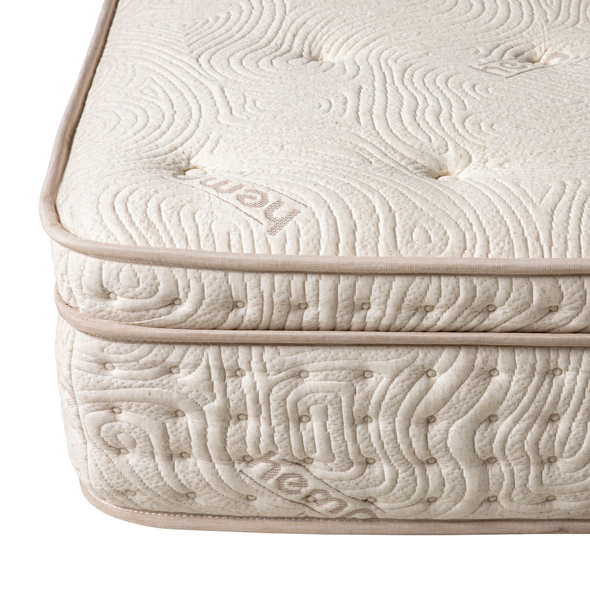 Close-up of an Annie Premium Mattress Double corner, showcasing textured beige fabric, button tufting, and branded text, emphasizing its memory foam and 5-zone pocket spring system for ultimate comfort.